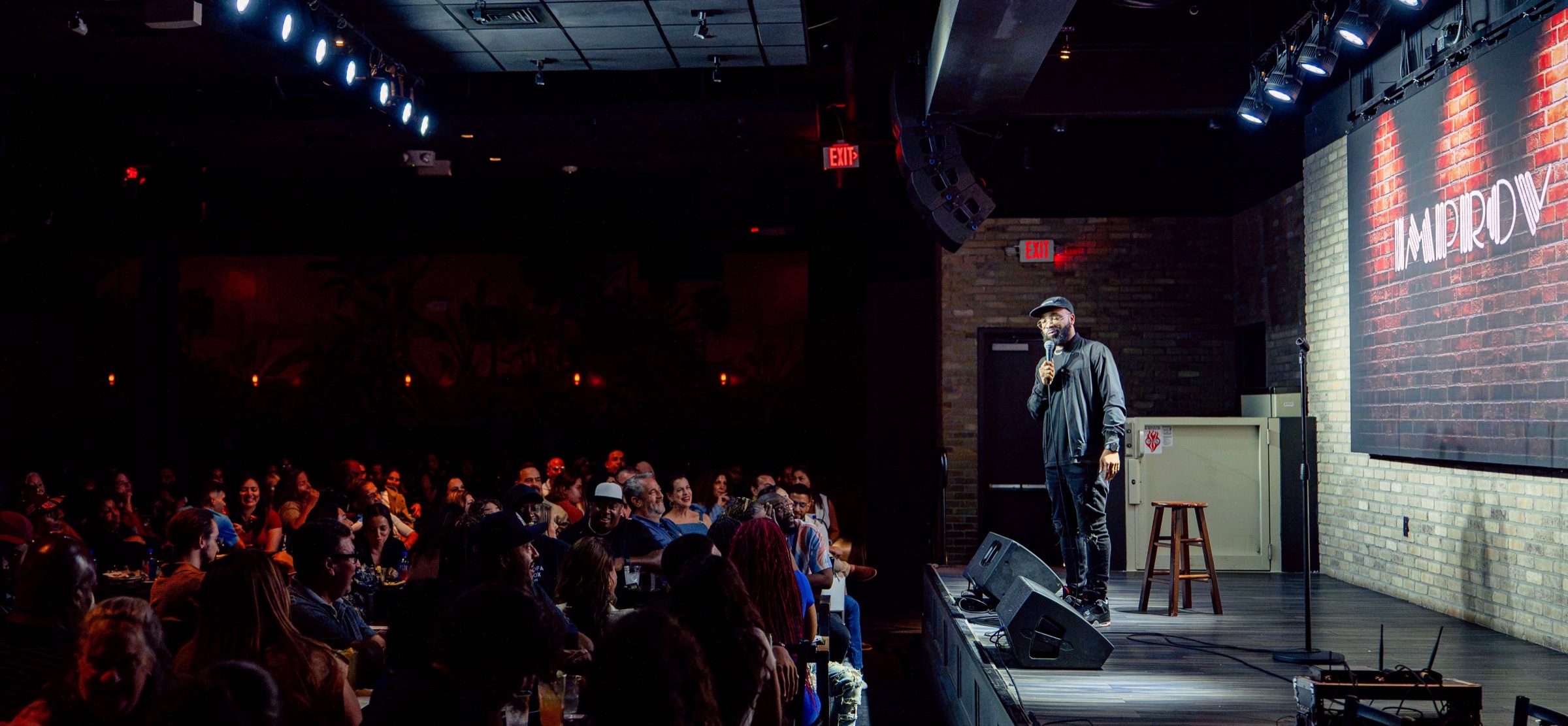 Malcolm McFly performing stand-up comedy on stage at the Improv